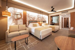 A modern hotel room with a sofa, two beds, a small table, and a TV. - Hotel Riu Palace Peninsula - All Inclusive (Cancun)