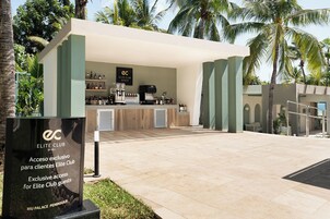 Zona de bar al aire libre con barra, estantes llenos de bebidas y un letrero que indica acceso exclusivo para miembros del Elite Club.
