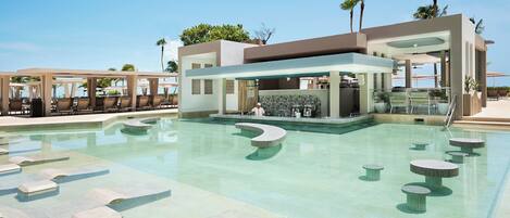 A modern pool area with lounge chairs and a bar.