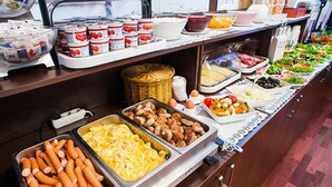 A buffet with various food items including hot dogs, macaroni, and salads. - Upper Room Hotel Kurfurstendamm (Berlin)