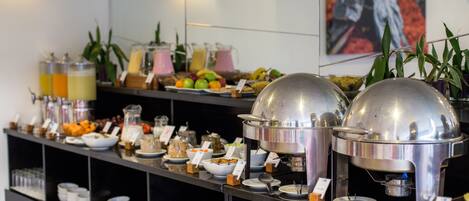 Una barra de buffet con diversos alimentos y bebidas.