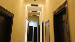 A hallway with recessed lighting, doors on both sides, and a ceiling with a decorative panel. - The Emerald Hotel (Cairo)
