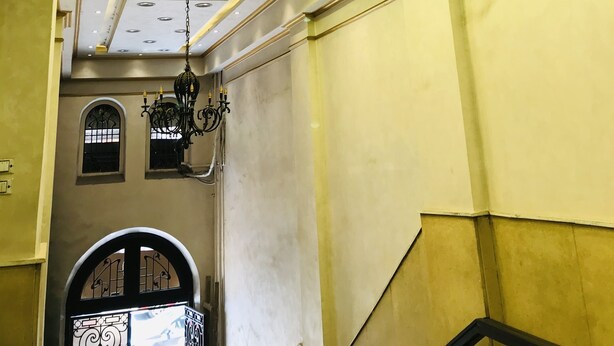 A hallway with a ceiling featuring recessed lighting and a chandelier. - The Emerald Hotel (Cairo)