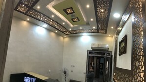 A hotel room with a decorative ceiling, a standing fan, and a door leading to another room. - The Emerald Hotel (Cairo)
