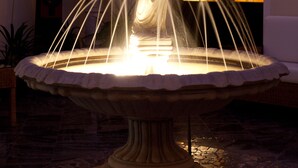 A fountain with water jets in a well-lit indoor area. - Aparthotel Vila Minka (Ljubljana)