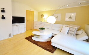 Leilighet – deluxe | Oppholdsområde | En 80-centimeters LCD-TV med kabel-kanaler samt TV