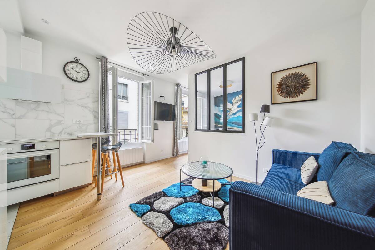 A modern living space with a kitchen, dining area, and seating area.