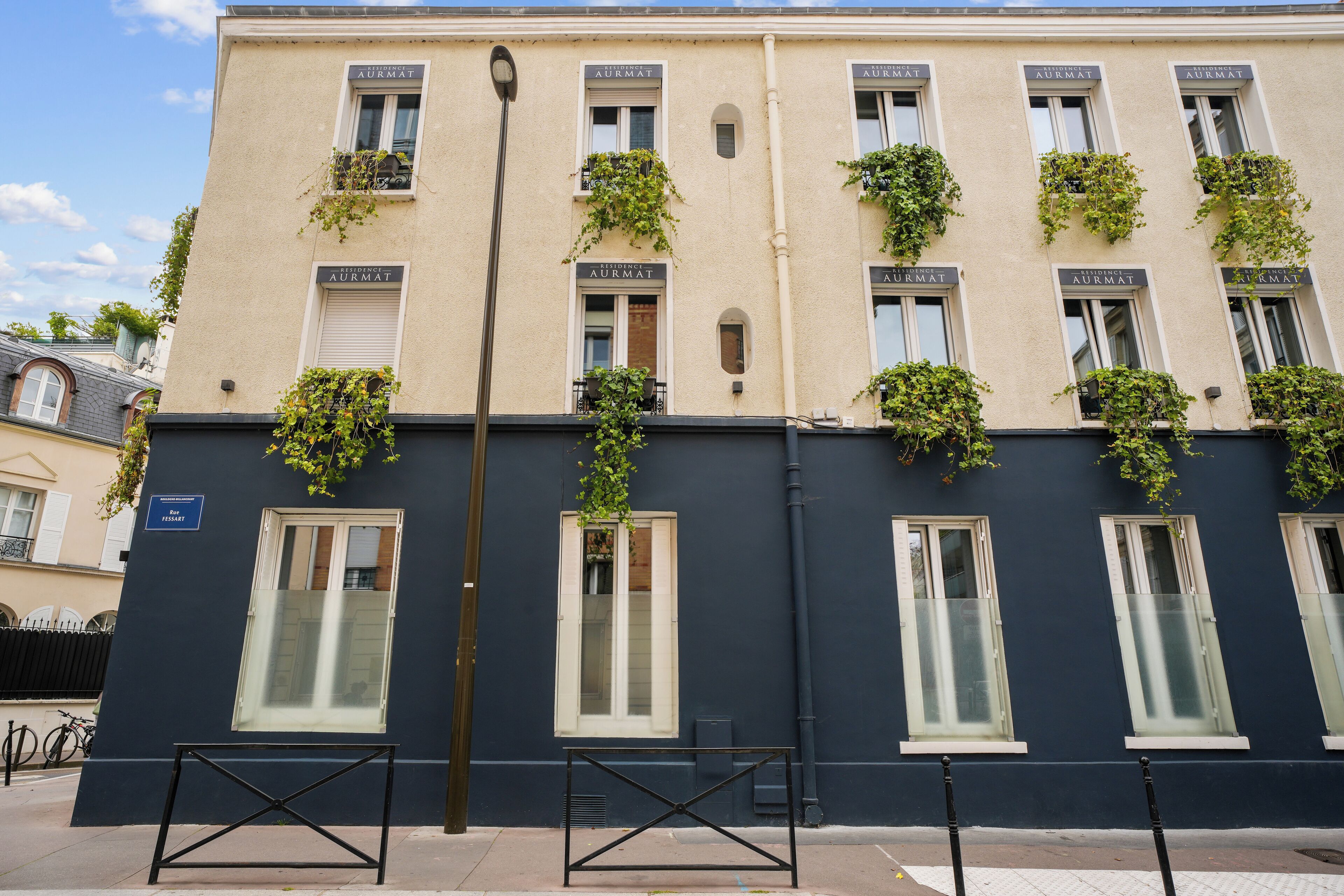 A building with multiple windows, some with shutters, and a sign indicating a restaurant.