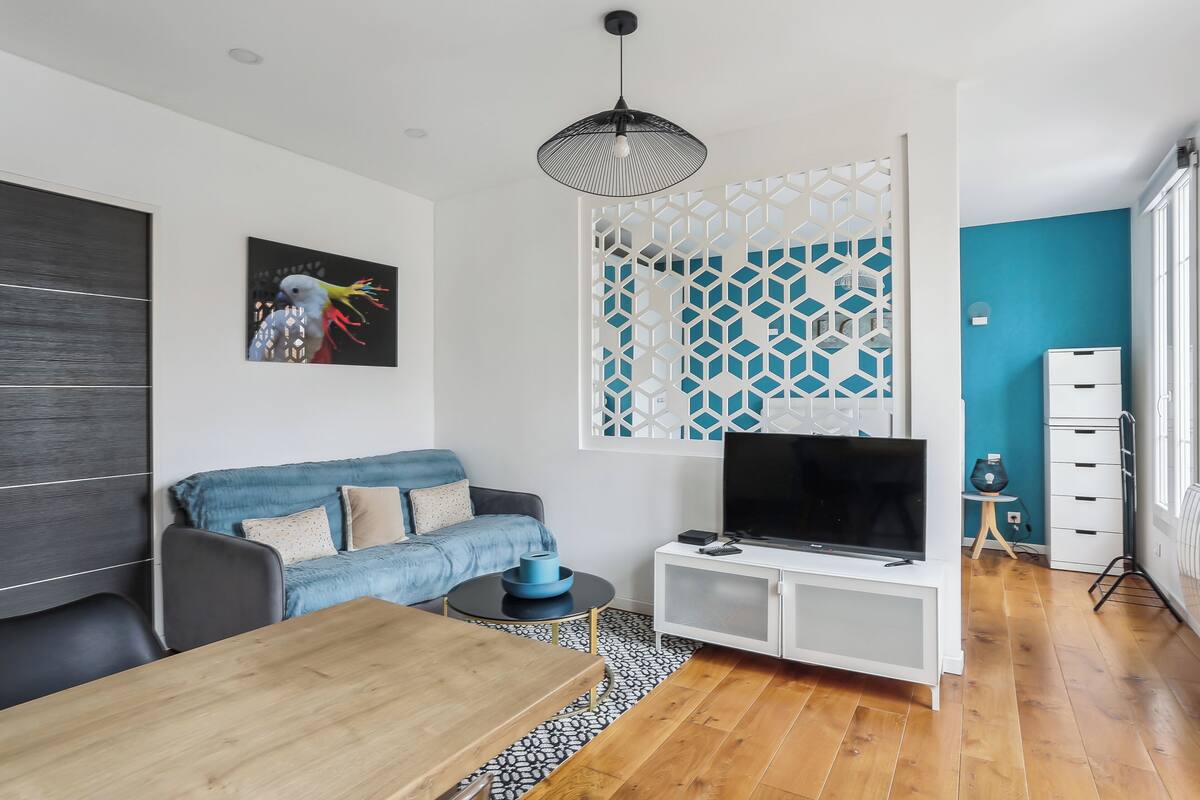 A modern living room with a sofa, TV, and dining table.