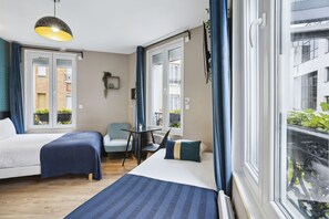 A hotel room with two beds, a small table, and a chair. There is a window with curtains, and a balcony is visible through the window. - Résidence Aurmat Appart Hôtel Paris Boulogne (Boulogne-Billancourt)