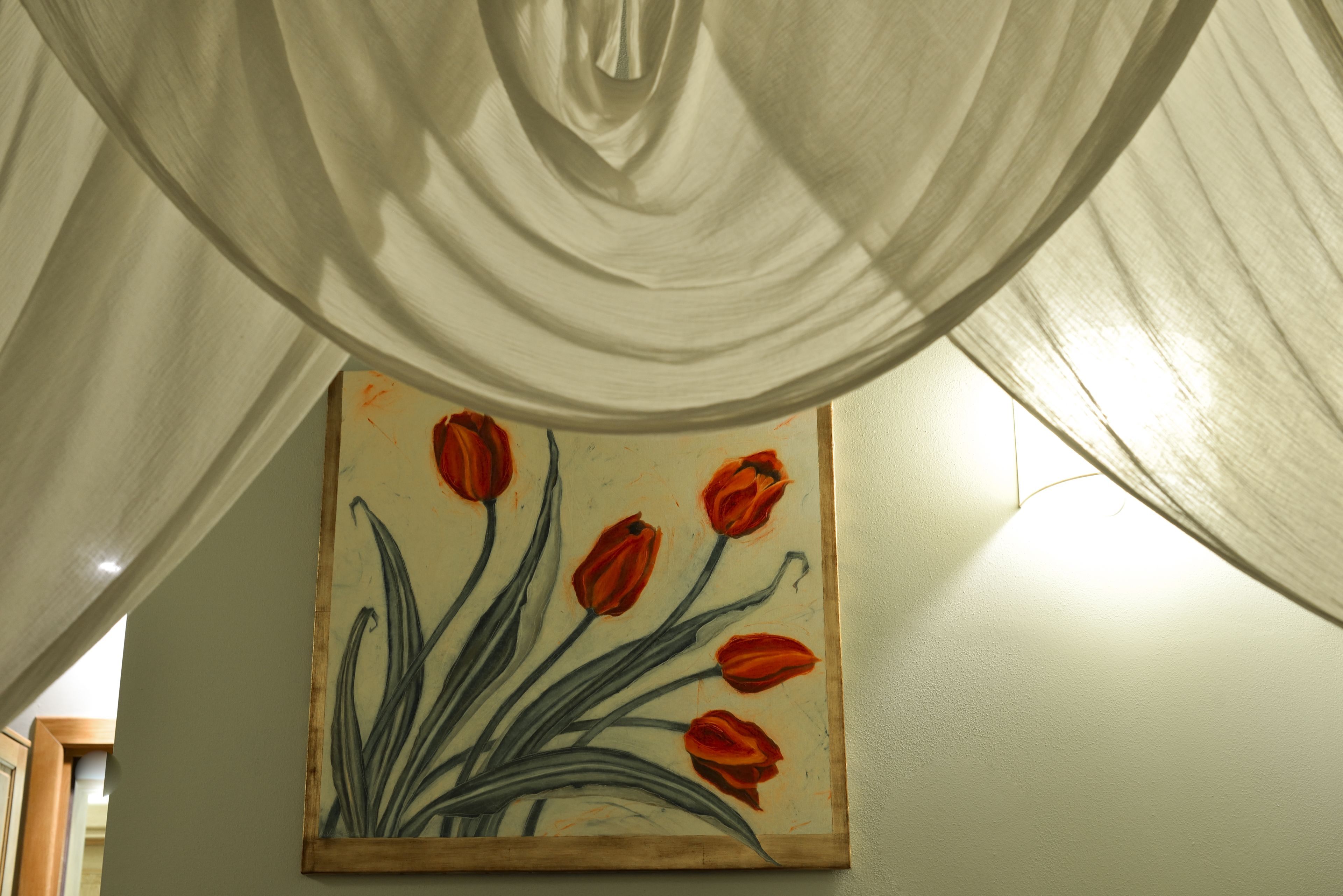 A painting of red tulips on a wall.