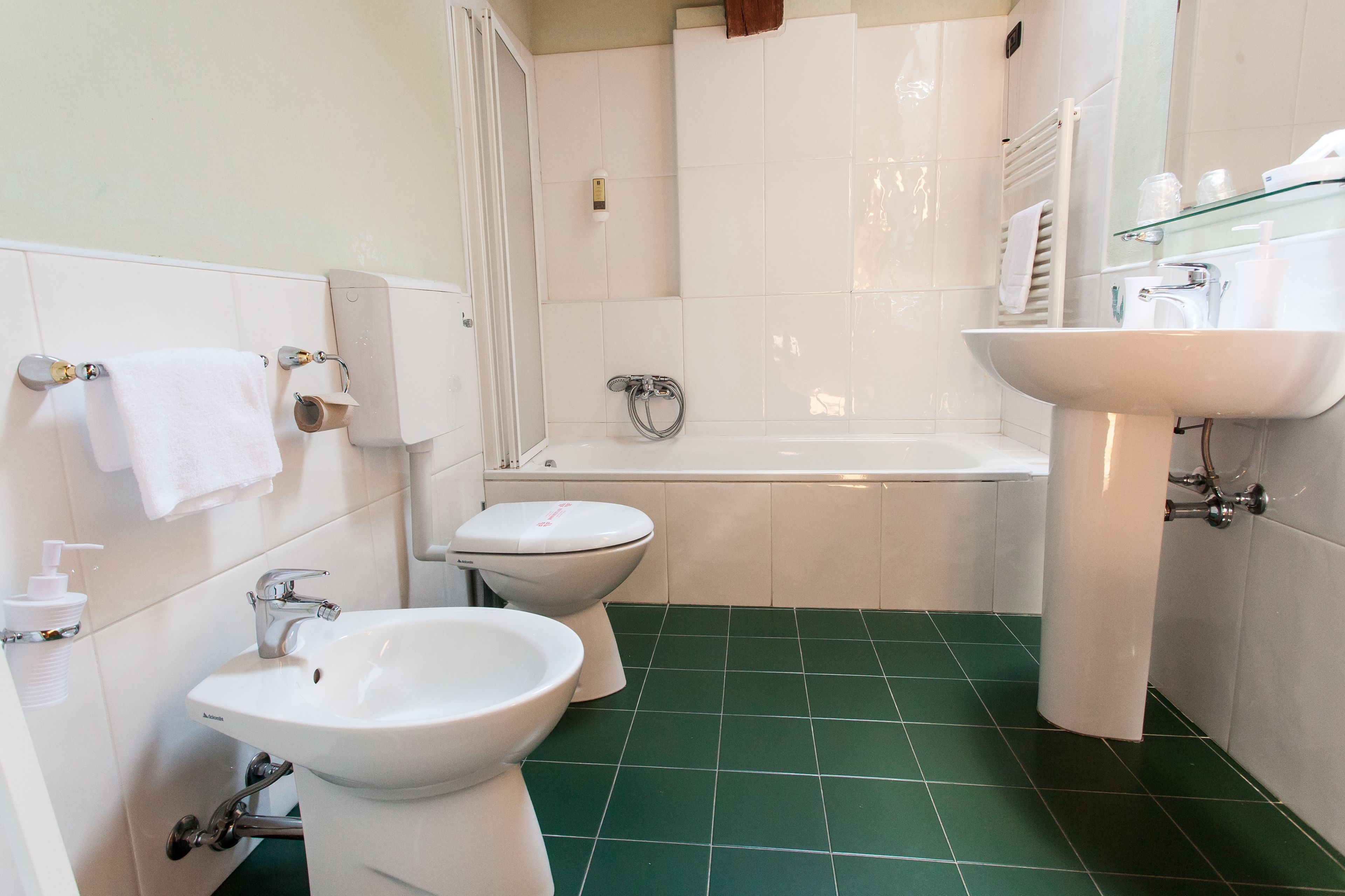 A bathroom with a bathtub, two sinks, and a toilet.