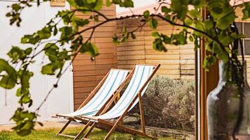 Two striped lounge chairs outside a wooden building with a sign that reads "DUCHIA".