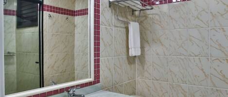A bathroom with a marble sink, a toilet, and a mirror.