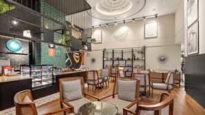 A modern interior with seating, a counter, and bookshelves. - Novotel Abu Dhabi Gate (Abu Dhabi)