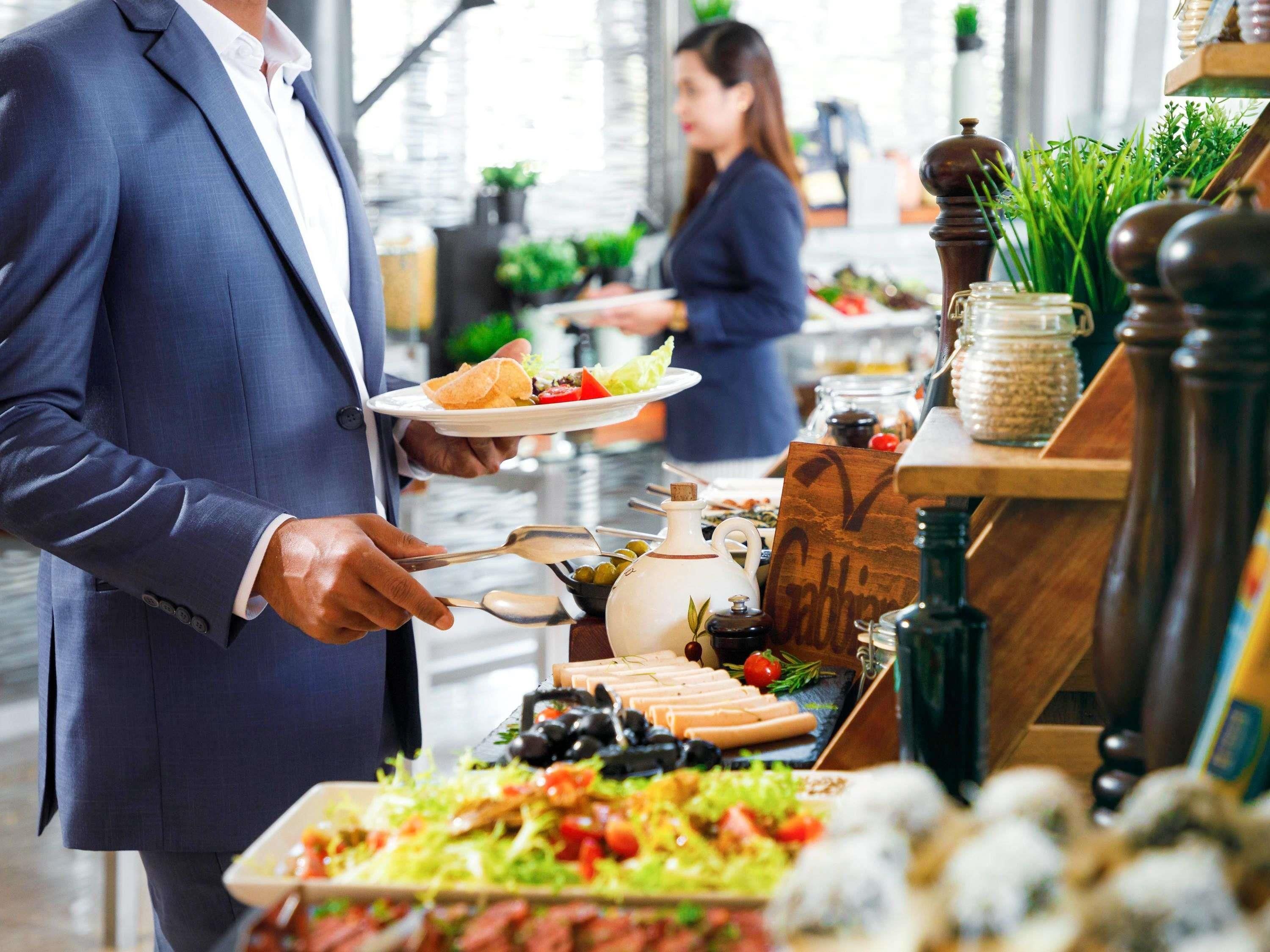 A buffet setup with various food items and condiments.