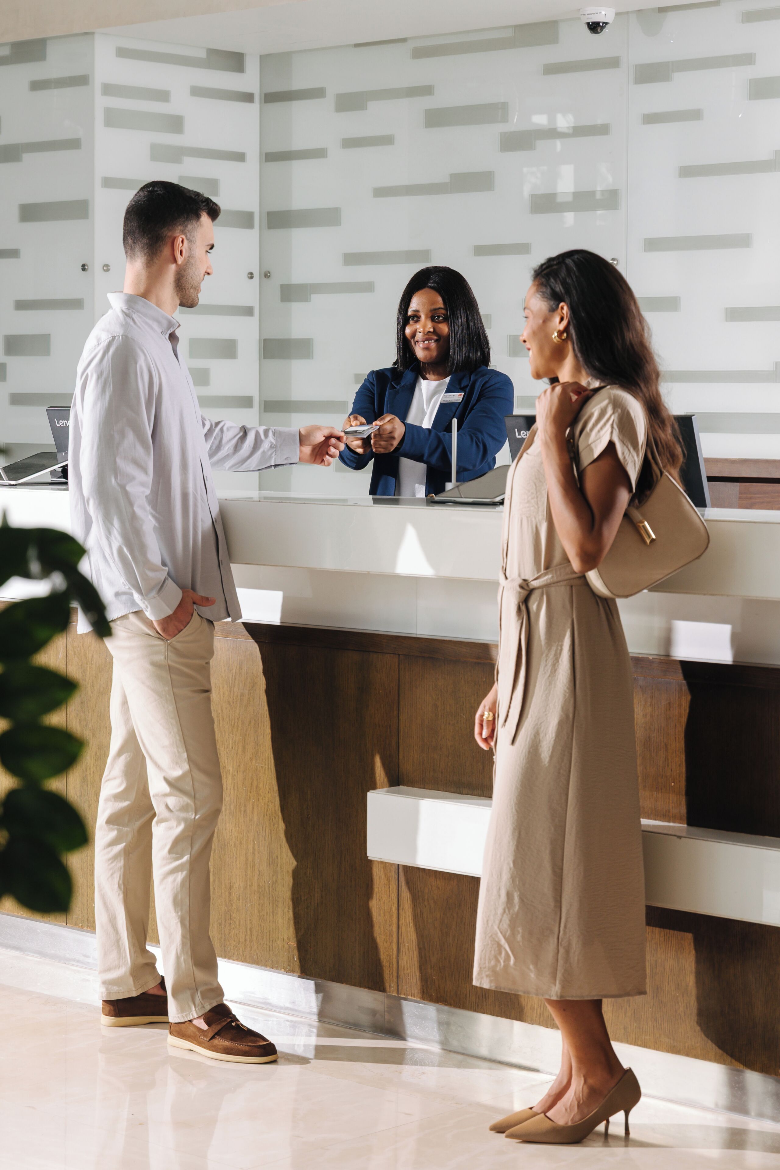A reception desk with a modern design, a laptop, and a security camera.