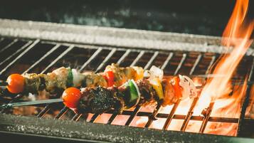 Una parrilla con brochetas de carne y verduras.