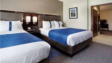 A hotel room with two beds, a nightstand, a desk, and a television.