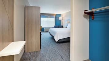 Habitación de hotel con cama, mesita de noche y vistas al exterior.