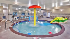 Ein Hallenbad mit Wasserrutsche, Liegestühlen und einer Schildkröten-Schwimmweste.