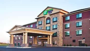 Welcome to the Holiday Inn Express & Suites, featuring a symmetrical design with a central entrance and multiple windows.
