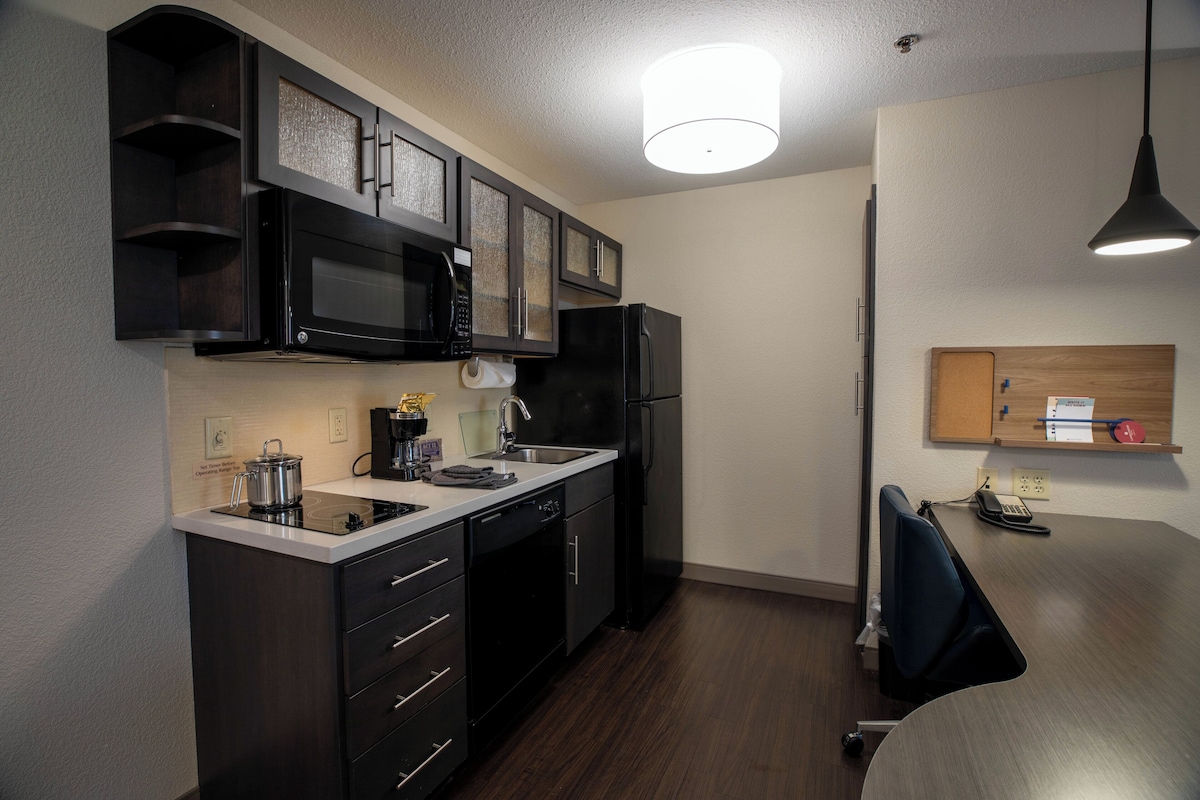 A compact kitchen with a microwave, stove, and refrigerator.