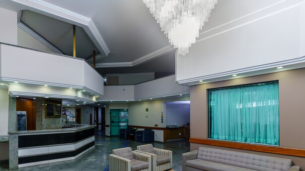 A spacious lobby with a reception desk, seating area, and a chandelier. - Hotel Augusta Boulevard (São Paulo)