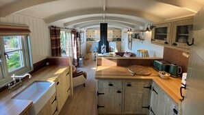 A spacious kitchen with wooden cabinets, a large island, and a built-in oven. - Holly Lodge Boutique B&B (Fakenham)