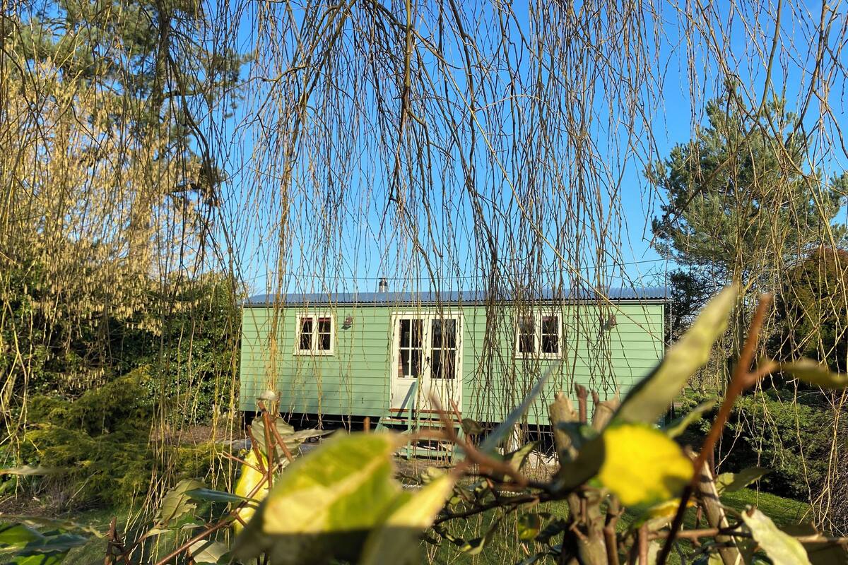Una casa verde con un porche pequeño y una ventana.