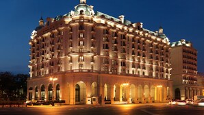 A large, historic hotel with multiple floors, arched windows, and a prominent dome.