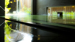 Un sol mouillé qui reflète la verdure et l’intérieur d’un bâtiment.