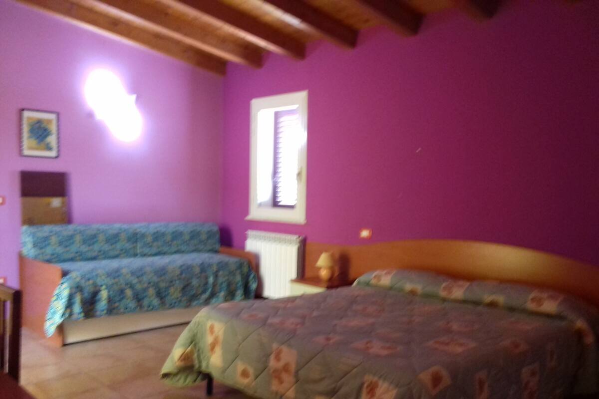 Una habitación con dos camas, un radiador y una ventana.