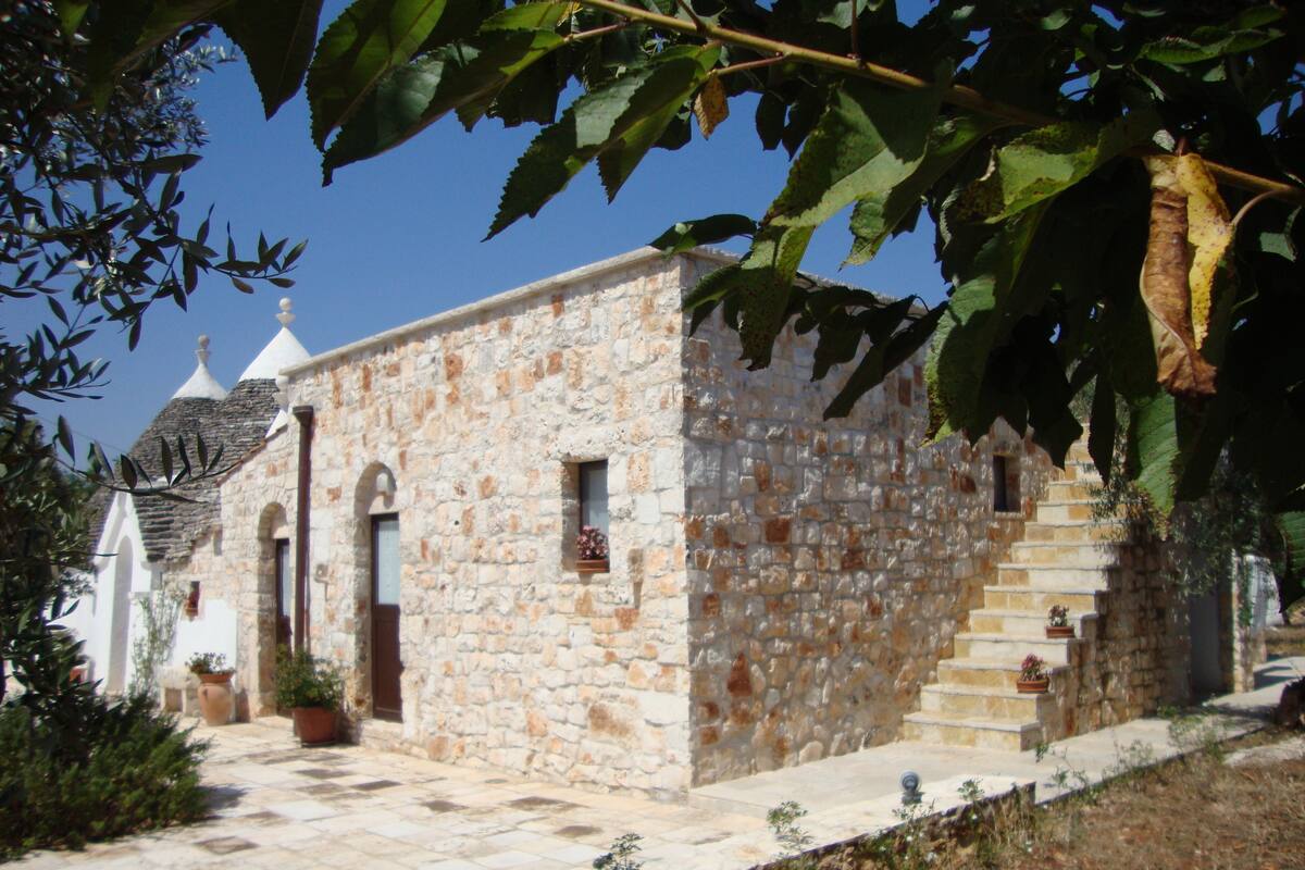Un edificio de piedra con una pequeña escalera y una puerta.