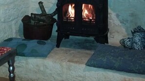 A stone fireplace with a black wood-burning stove.