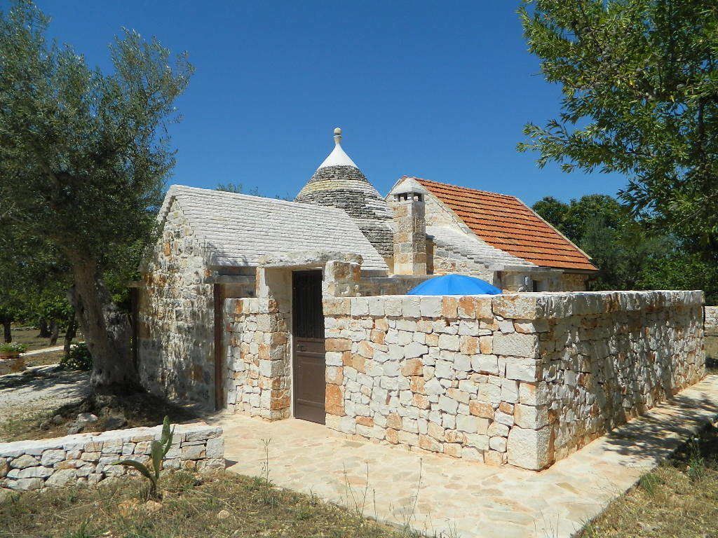 Un bâtiment en pierre, doté d’un toit en tuiles, d’une petite coupole et d’un mur de pierre qui l’entoure.