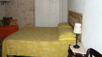 Un dormitorio con cama, mesita de noche, lámpara, cabecero de madera y una puerta.