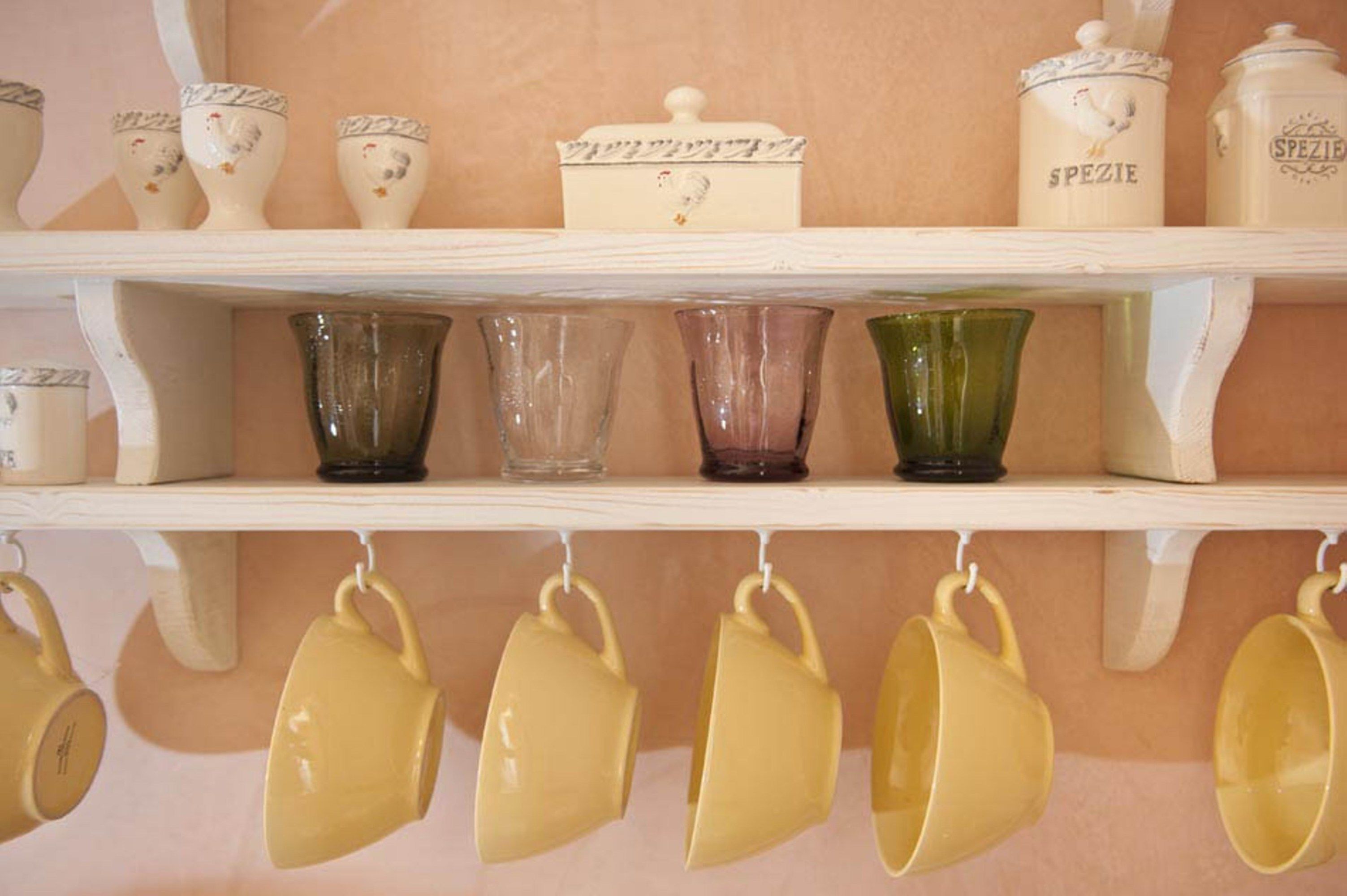 A shelf with various glassware and ceramic containers.