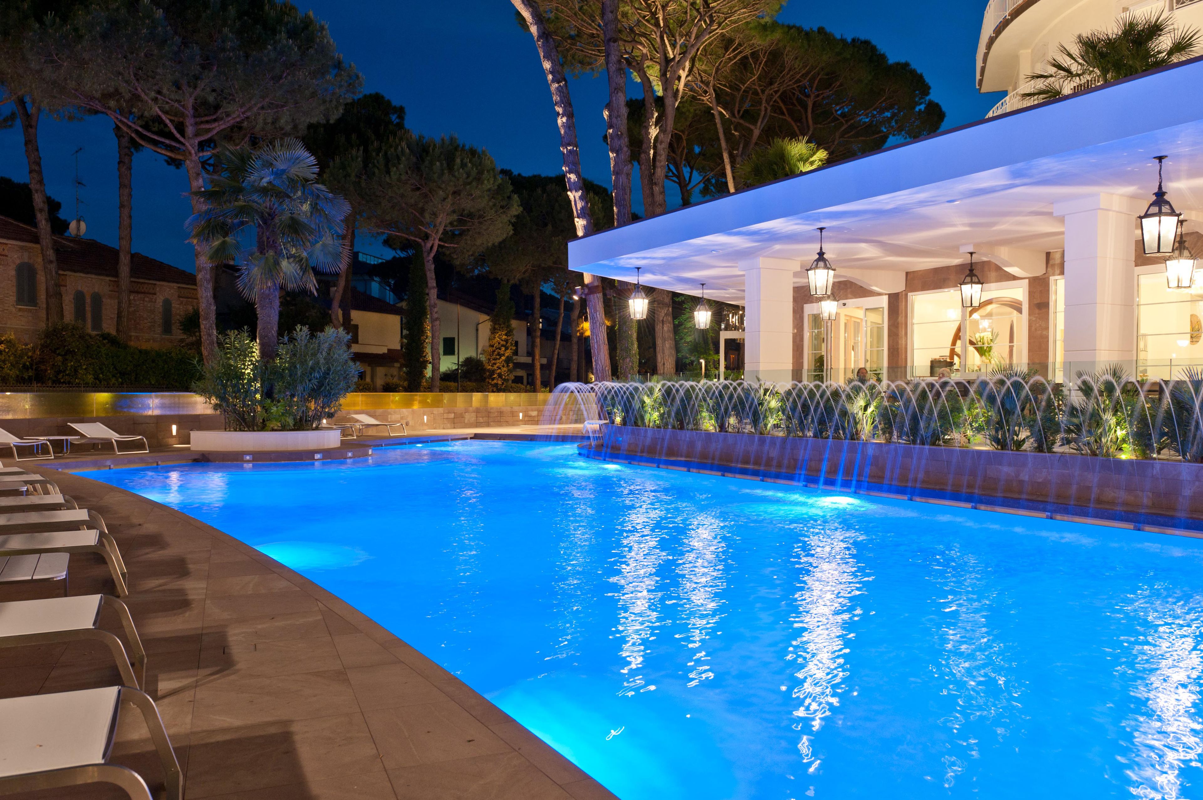 Una piscina cubierta, una piscina al aire libre, sombrillas, tumbonas