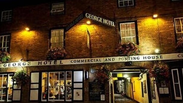 The exterior of the George Hotel, featuring a commercial and posting house below the main entrance.