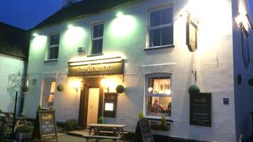 Vista frontal de la propiedad por la tarde o noche