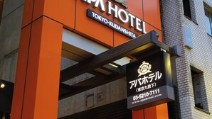 Fachada del hotel APA Tokyo-Kudan-shita, con un llamativo color naranja y señalización.