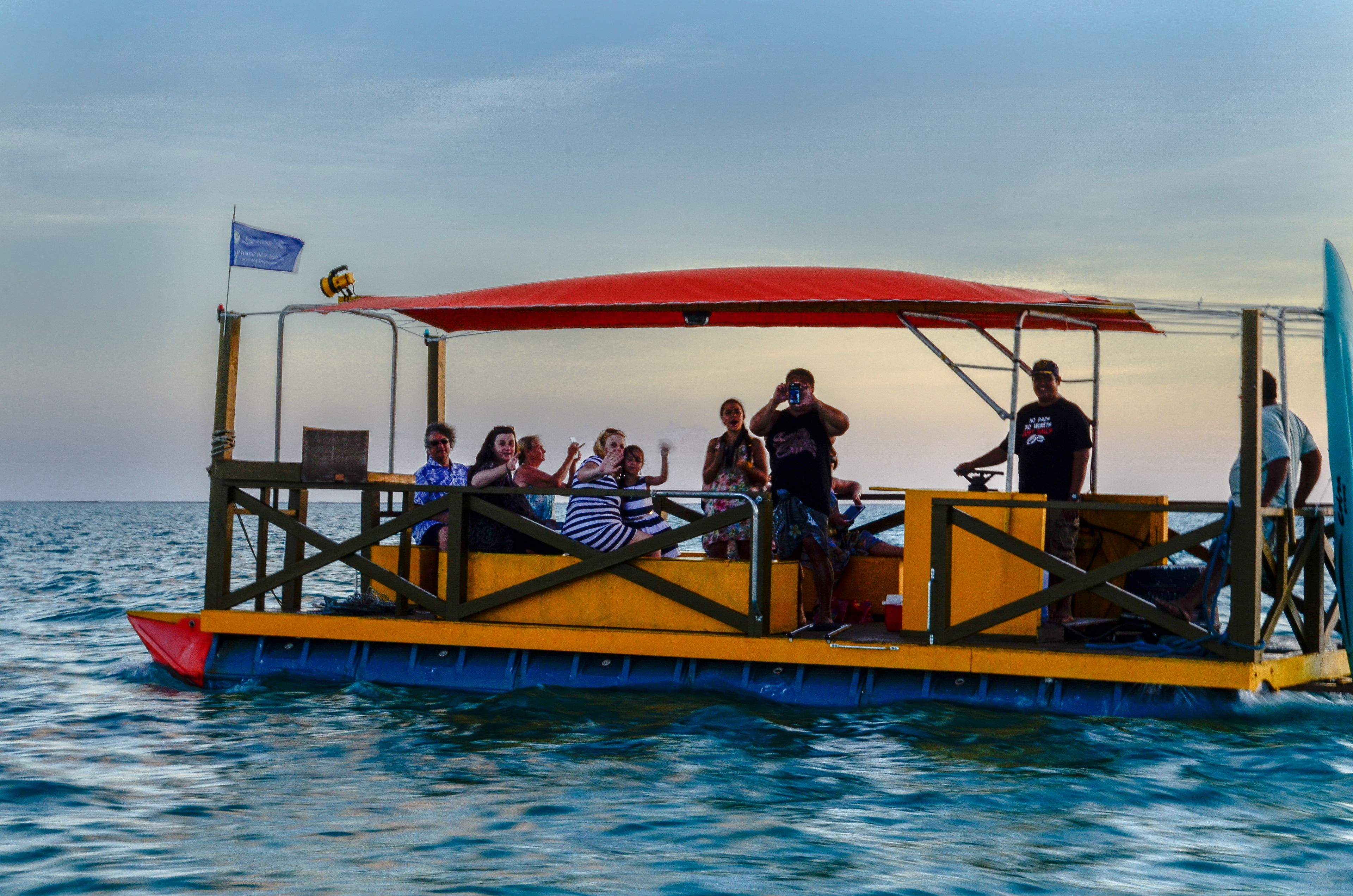 Un bote con toldo rojo y pasajeros.