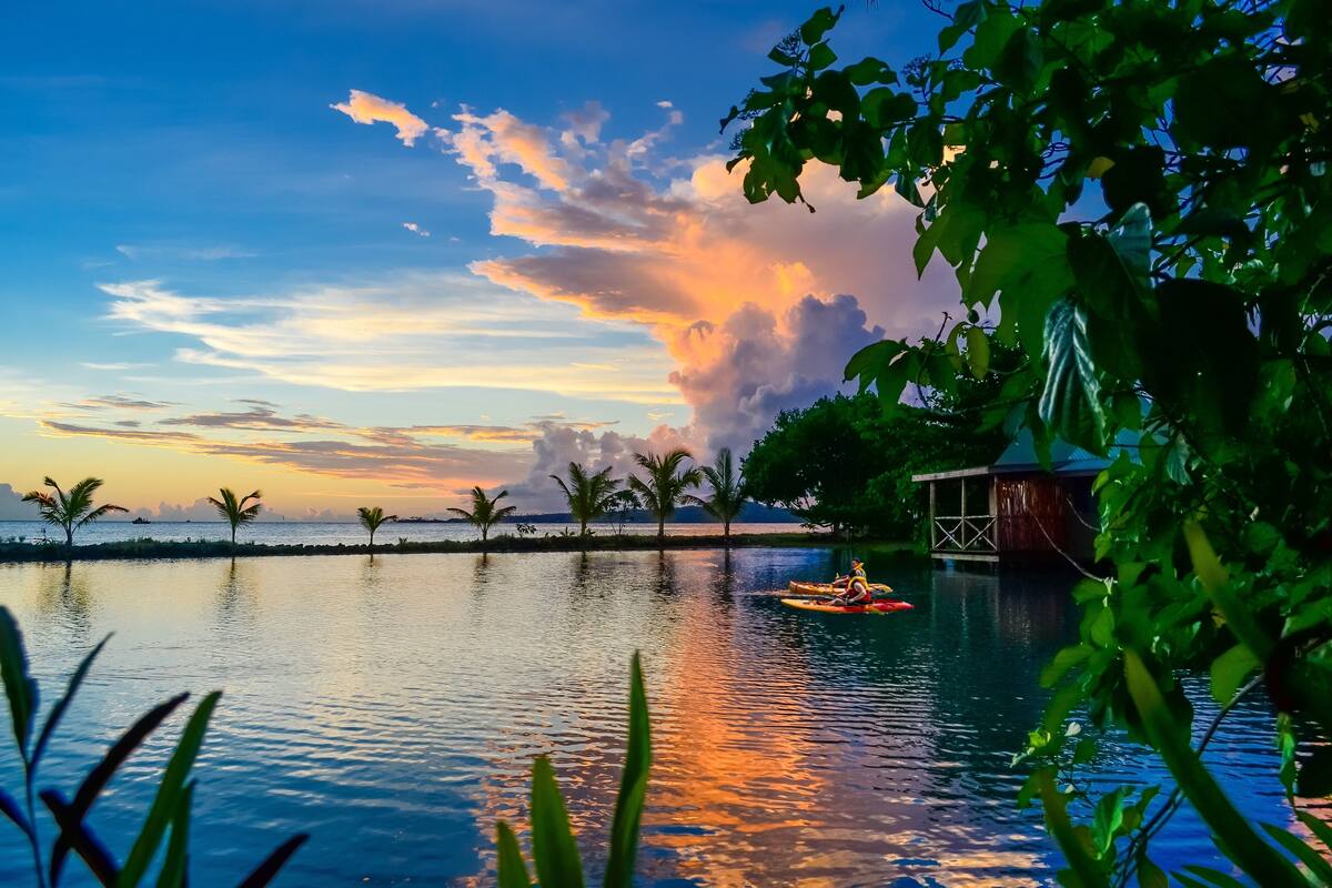 A serene lakeside view with a wooden structure and a small boat.