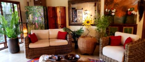 A cozy living room with wicker furniture, a sofa, and a coffee table.