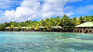 A beachfront resort with overwater bungalows, clear turquoise water, and lush palm trees. - Le Vasa Resort (Cape Fatuosofia)