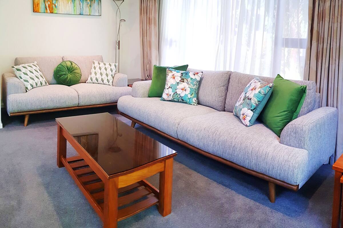 A living room with a sofa set, a coffee table, and a painting on the wall.