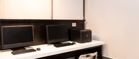 Un espacio de oficina moderno con dos monitores, un teclado, un ratón e impresora Dell sobre un escritorio blanco.