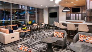 Een moderne zithoek met banken, fauteuils en een bar met krukjes.