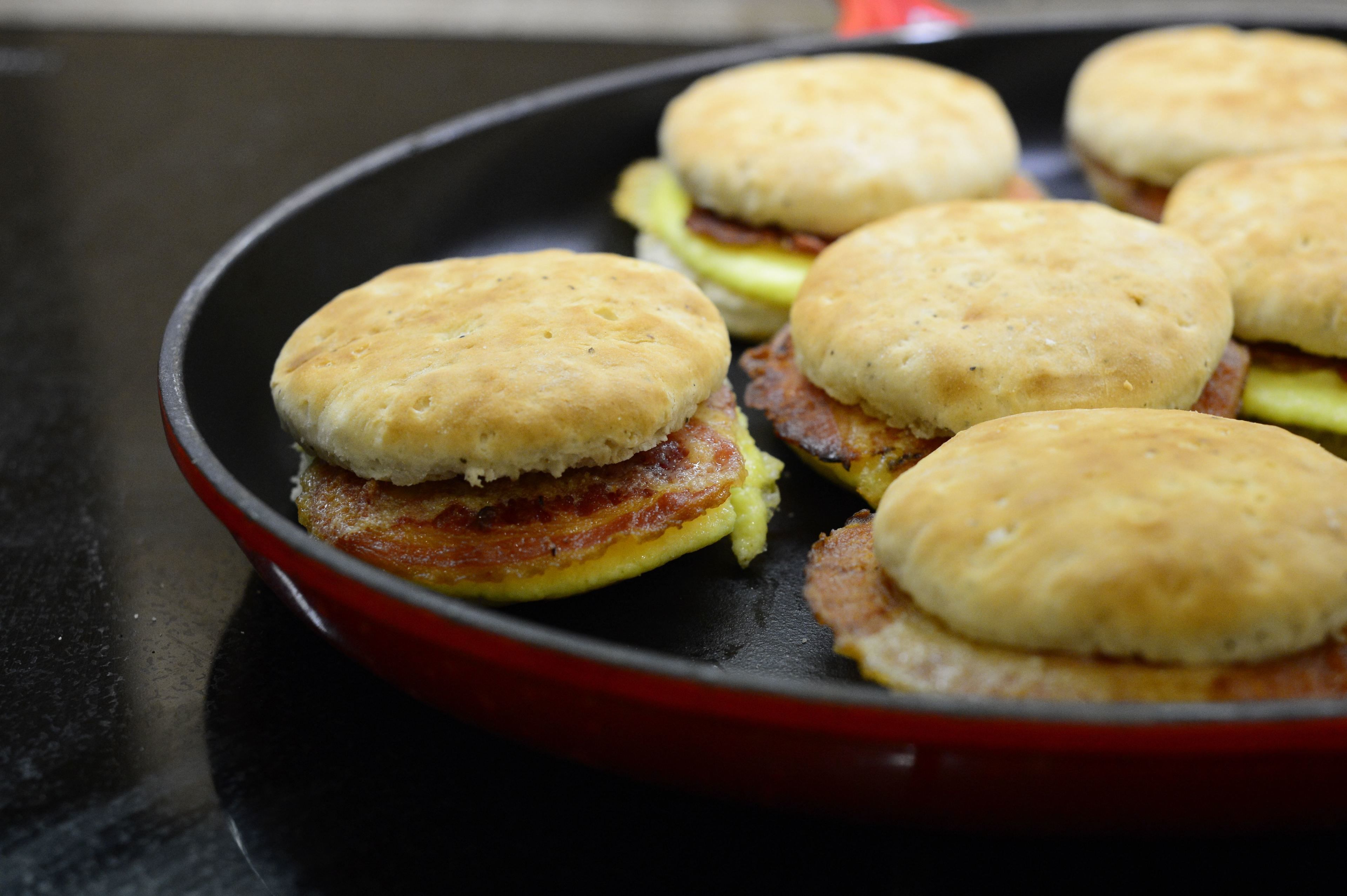 A skillet with breakfast sandwiches.